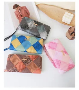 Vue d'un groupe de quatre portefeuilles longs élégants colorés pour femmes sur fond blanc.