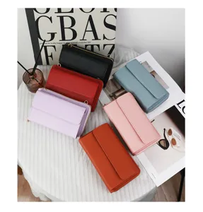 Borse a tracolla multifunzionali per cellulari in vari colori su un tavolo elegante.