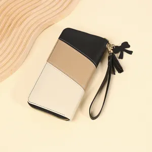 Dettaglio del portafoglio lungo da donna con design patchwork nero, marrone e crema.