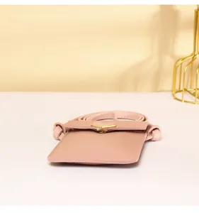 Macro view of pink PU leather crossbody phone bag with heart-shaped gold metal clasp
