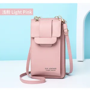 Primo piano di un'elegante borsa a tracolla rosa chiaro in pelle per cellulare