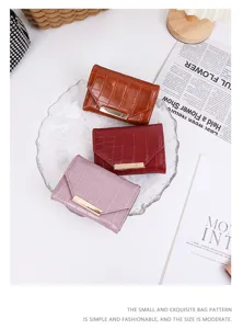 Vue détaillée de trois mini portefeuilles en cuir croco marron rouge et lavande.
