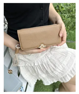 Gros plan d'un long portefeuille chic en cuir grainé kaki avec un fermoir doré
