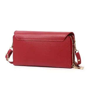 Detail view showing the back side of a red double-layered crossbody wallet with gold hardware