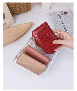Close-up of crocodile embossed PU leather wallet with elegant pearl chain accessory