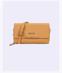 Yellow faux leather crossbody phone bag with Forever Young metal bar detail
