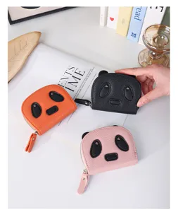 Macro view of cute panda cartoon coin purses in pink black and orange colors on desk