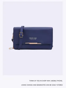 Macro view of blue crossbody phone bag with gold-tone hardware and buckle detail