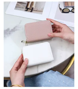 Detailed view of two lychee grain leather double zipper card holders in pink and white colors