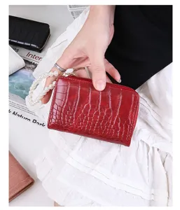 Red faux leather crocodile pattern wallet featuring a decorative pearl hand strap