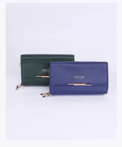 Close-up of green and blue double-layer women's wallets with gold-tone hardware.