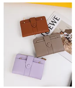 Tres elegantes carteras de cuero PU en marrón, gris y púrpura con remaches dorados.