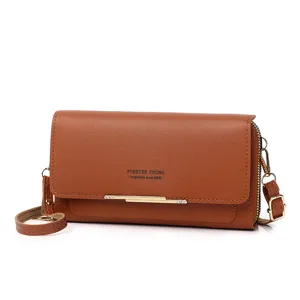 Macro view of brown faux leather crossbody phone bag for women with elegant flap design