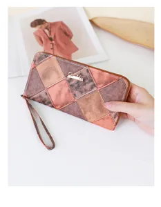 Gros plan d'un long portefeuille patchwork pour femme tenu à la main avec dragonne