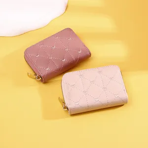 Detailed view of two heart-quilted zipper card wallets in pink and mauve tones
