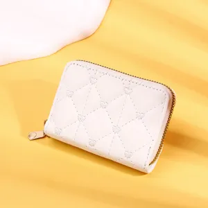 Detail macro view of a stylish white women's short wallet with quilted heart patterns and zip
