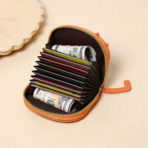 Detail view of orange cat accordion card holder wallet filled with cards and cash.