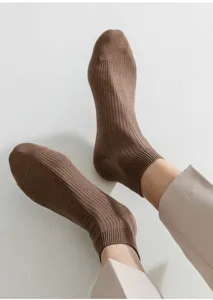 Nahaufnahme brauner gerippter Baumwoll-Herrensocken, feine Textur und atmungsaktives Stricken.