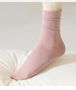 Close-up of comfortable pink ribbed crew socks worn on foot, showing soft cotton texture.