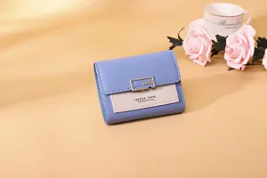 Detaillierte Nahaufnahme eines blau-beigen Damen-Mini-Portemonnaies mit Metallschließe