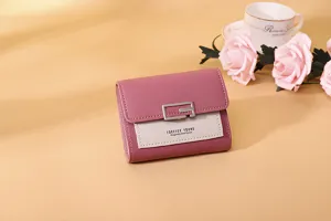Nahaufnahme der rosa Damen-Kurzbrieftasche mit Metallschnalle und Forever Young Text