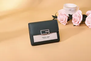 Detailansicht einer dunkelgrünen und beigen Damen-Bifold-Geldbörse mit Metallschnalle