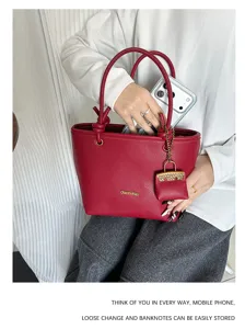 Close-up of stylish red lychee grain tote bag showing ample storage for a mobile phone