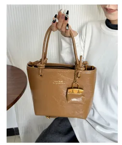 Vintage brown faux leather tote bag with bucket shape and decorative charm detail