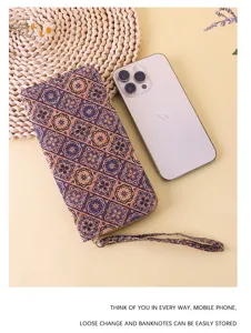 Elegant bohemian floral long wallet shown next to a smartphone for size comparison