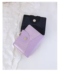 Detail view of purple and black crocodile texture wallets with vintage gold metal clasps
