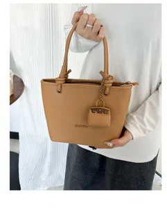 Detailed view of camel lychee pattern tote bag with a matching mini pouch charm