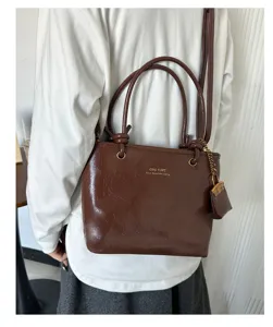Vintage dark brown leather tote bag with glossy texture and knotted handles detail