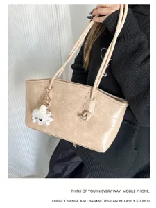 Fashionable beige crocodile pattern tote bag with plush charm for daily commute
