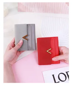 Detail of two matte PU leather tri-fold wallets in grey and red with V-shaped metal clasp.