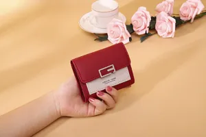 Nahaufnahme einer Hand, die eine stilvolle, rot-beige kompakte Mini-Ledergeldbörse hält