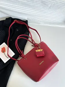 Elegant red lychee grain tote bag with adjustable shoulder strap and mini purse charm