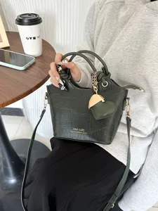 Elegante borsa a secchiello verde scuro motivo coccodrillo con ciondolo a cuore e tracolla