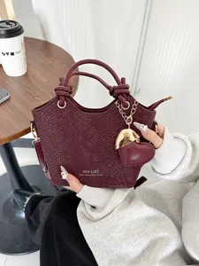 Borsa a mano a secchiello in ecopelle bordeaux con ciondolo a cuore e manico annodato