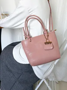 Vintage pink glossy leather bucket bag with double handles and gold charm