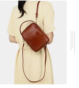 Macro view of cute brown mini crossbody bag with crocodile animal patch on model