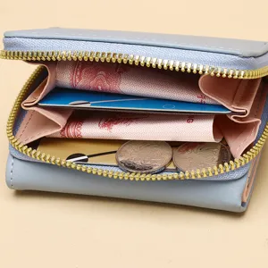 Vue détaillée des compartiments internes et doublure rose du portefeuille bleu clair