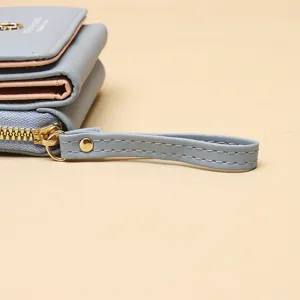 Gros plan d'un portefeuille bleu montrant les coutures, la fermeture éclair et la dragonne