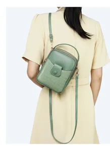 Back view of a mini stone pattern green crossbody bag worn by a model in a yellow dress