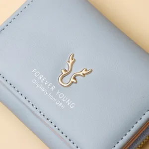 Vue détaillée d'un portefeuille en cuir bleu avec logo bois doré et texte Forever Young.