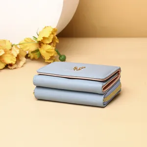 Vue détaillée du portefeuille bleu clair à trois volets avec fermeture éclair et cerf