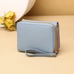 Vue détaillée d'un portefeuille pliable bleu clair avec une fermeture éclair dorée élégante