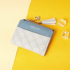 Detailed view of stylish two-tone women's wallet featuring heart charm and decorative tassel