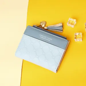 Detailed view of women's light blue patchwork wallet with stylish tassel and heart charm
