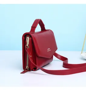 Zijaanzicht van een rode multifunctionele crossbodytas met ritsvak en details van de riem