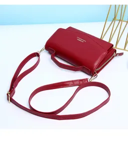 Gedetailleerde weergave van een rode minimalistische crossbodytas met verstelbare riem